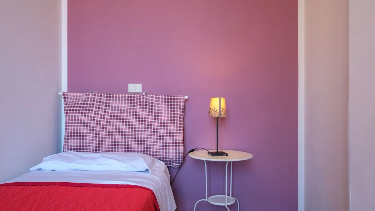 Quadrilocale Superior – camera da letto con copriletto rosso